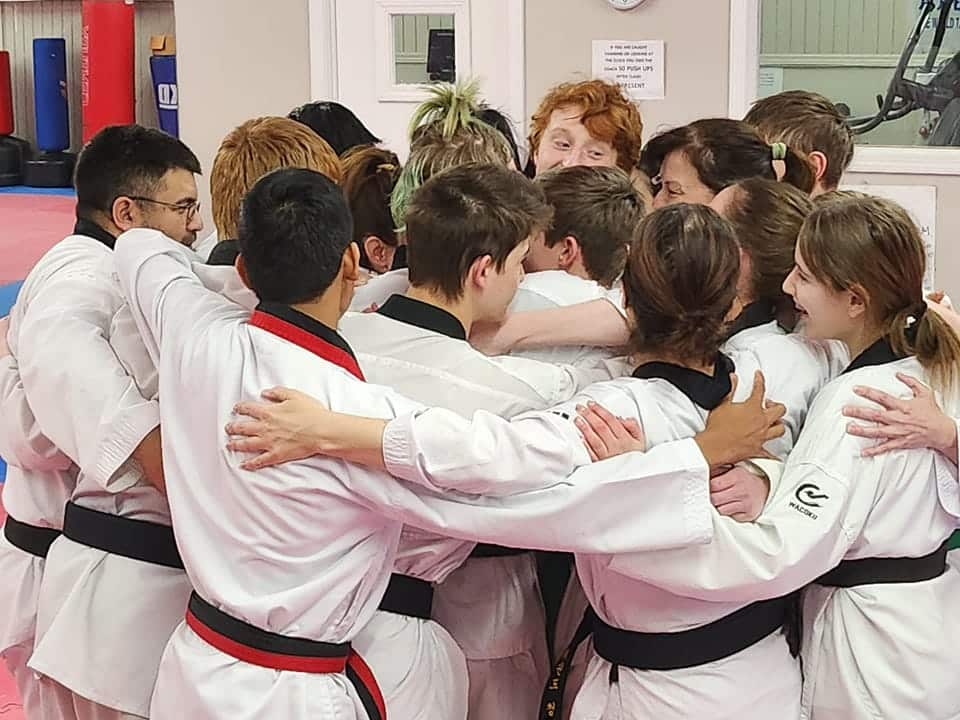 Midwest Tae Kwon Do kids in gi group hug.